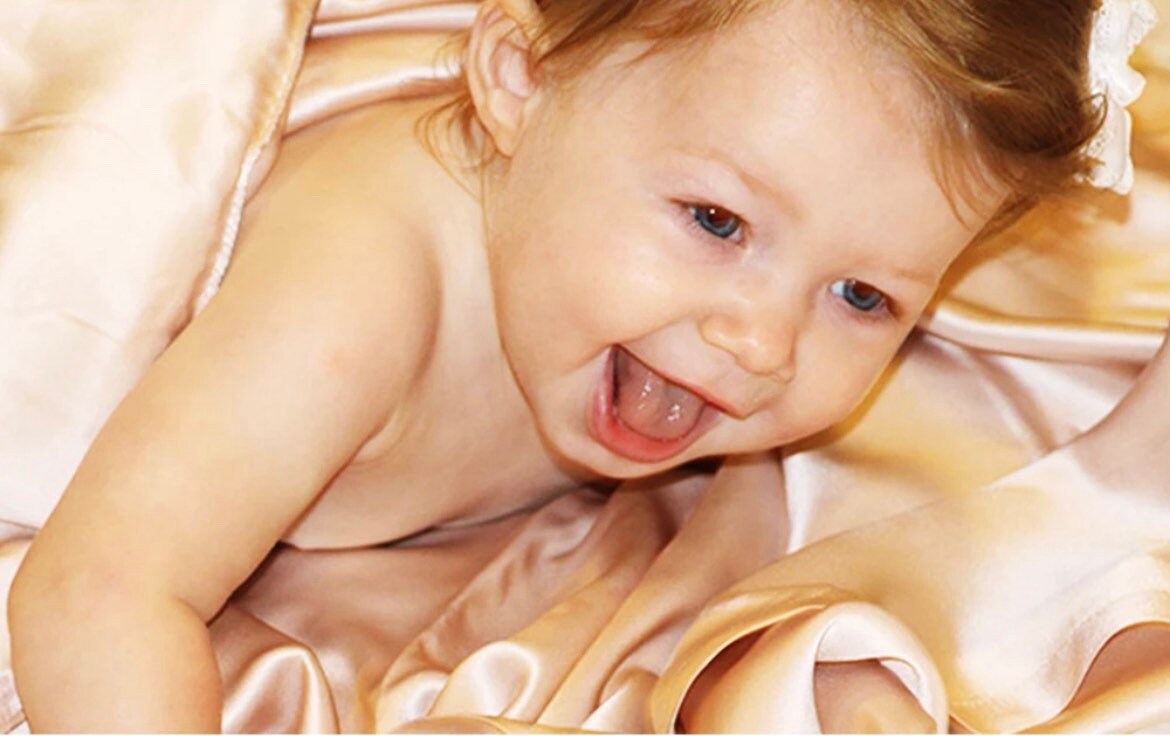 baby on silk bed sheet